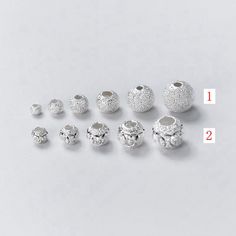 six different sizes and shapes of beads on a white surface with the numbers 1 - 2