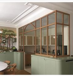 a kitchen with green cabinets and a white table