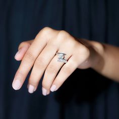 a woman's hand with a diamond ring on it