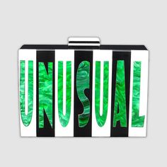 Embrace your weird and wild side with this sleek acrylic Cyndi clutch that features pearlized green letters spelling out "Strange" on one side and "Unusual" in the same gorgeous swirled green on the other side. Black and white stripes and a black and white top latch set off the letters in style. With plenty of space inside for your night-out essentials (any cell phone, keys, lipstick, and our slim Card Wallet), and a removable gold metal chain shoulder strap, this clutch is a versatile and uniqu Modern Green Evening Clutch, Trendy Green Clutch As Gift, Trendy Green Clutch For Gift, Trendy Green Clutch As A Gift, Trendy Green Clutch For Formal Occasions, Green Letters, Strange And Unusual, Acrylic Clutch, Black And White Top