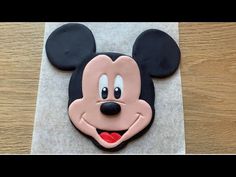 a mickey mouse cookie on top of a piece of paper with the shape of a face