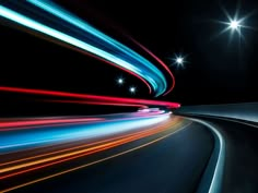 motion blur photograph of light streaks on the road at night with stars and street lights