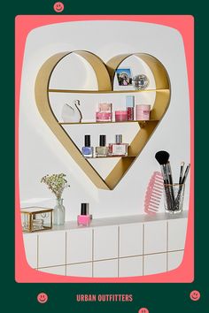 there is a heart shaped shelf on the wall with makeup and cosmetics items in it