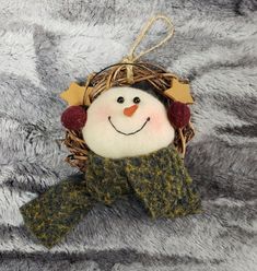 a snowman ornament hanging on a gray blanket