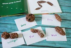 four cookies are sitting on top of paper with words in front of them and an open book