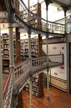 the inside of a library with many bookshelves and stairs leading up to them