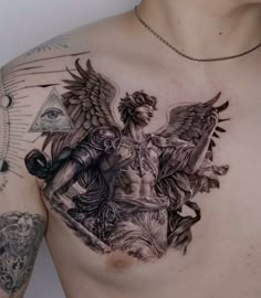 a man's chest with an angel tattoo on it and other tattoos around his neck