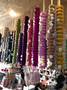 many different colored yarns are hanging from the ceiling