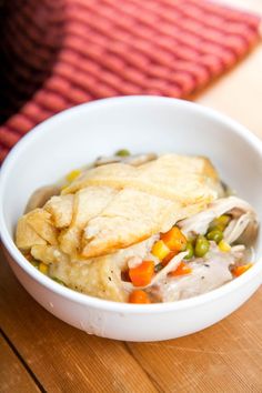 a white bowl filled with food on top of a wooden table