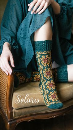 a woman sitting on top of a chair with her legs crossed and wearing socks that say solaris