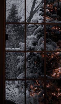 a window with snow on it and trees outside