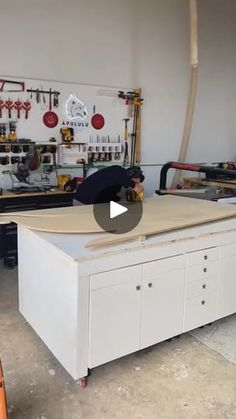 a man is working on a table in a garage with tools and other work equipment