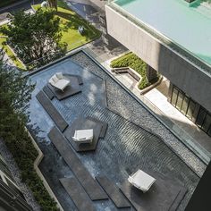 an aerial view of a courtyard with lounge chairs and water feature in the foreground