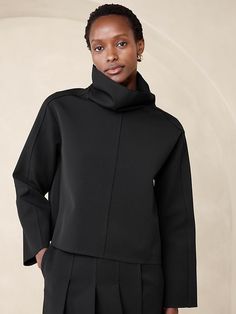 Modern Tops For Workwear, Modern Funnel Neck Top For Fall, Oversized Turtleneck Top For Work, Modern High Neck Tops For Workwear, Chic Funnel Neck Outerwear For Work, Modern Blouse For Layering In Fall, High Neck Tops With Minimal Stretch For Work, Sleek Tops For Workwear With Minimal Stretch, Structured Tops For Fall Workwear