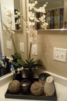 there is a vase with flowers in it on the bathroom sink