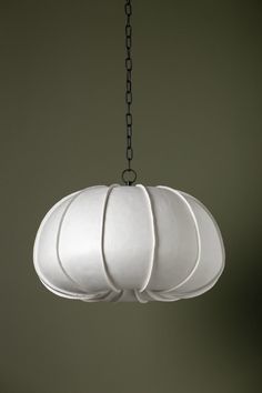 a white light fixture hanging from a chain