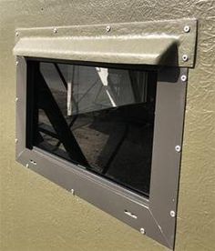 an open window on the side of a building with metal bars and rivets