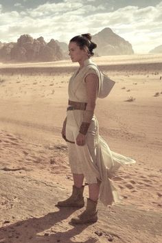 a woman standing in the desert wearing a dress