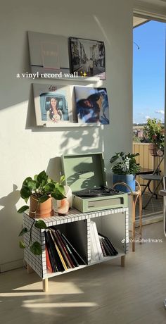 a record player sitting on top of a table next to a plant and potted plants