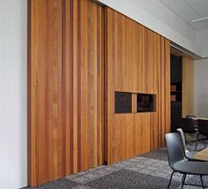 an empty meeting room with wooden walls and chairs