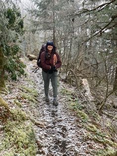 a woman hiking up a trail in the woods