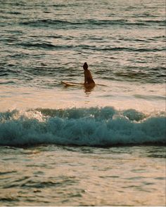 a person riding a surf board on a wave in the ocean at sunset or dawn