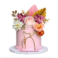 a pink and gold cake with flowers on top