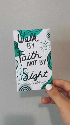 someone holding up a piece of paper with the words walk by faith not by sight