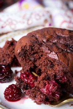 a piece of chocolate cake on a plate with cherries