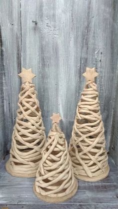 three small christmas trees made out of twine and burlock with stars on top