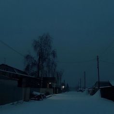 a dark street with snow on the ground