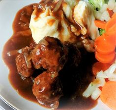 meatballs, mashed potatoes and carrots on a plate with gravy