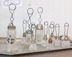 there are many glass vases on the table with metal wire attached to each one