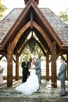 the bride and groom are getting married in front of an outdoor gazebo at their wedding