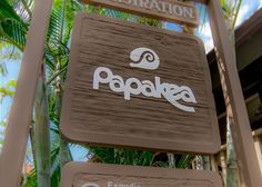 the sign for papaoke in front of some palm trees