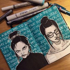 an open notebook with drawings of two women on it and some markers next to them