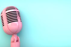 an old fashioned pink microphone against a blue background