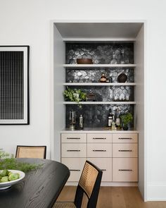 a dining room table and chairs with built in shelves