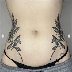 a woman's stomach with tattoos on the side and flowers in the lower part