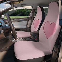 the interior of a car with two pink hearts on it's seat covers and steering wheel