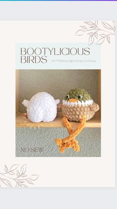 two crocheted birds sitting on top of a shelf