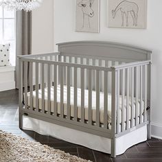 a baby crib in a room with pictures on the wall