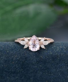 an engagement ring with a pink morganite surrounded by white diamonds on a blue surface