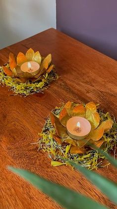 two candles sitting on top of a wooden table