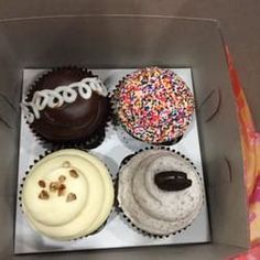 a box filled with different types of cupcakes