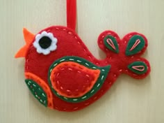 a red bird ornament hanging on a wall