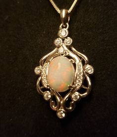 Gorgeous Natural White Ethiopian Opal Full Of Pink and Red Fire! This Opal Is A Bit Camera-Shy, So Be Sure To See Video! Rococo Chandelier Necklace With 9+ CZ Accents Giving Sparkle. Sterling Silver Chain. Great Gift! Gift Box Included Silver Oval Necklace With Bail, Ornate Oval Sterling Silver Necklace, Sterling Silver Necklaces With Oval Accent Stones, Sterling Silver Oval Necklace With Accent Stones, Oval Sterling Silver Necklace With Accent Stones, Rococo Chandelier, Chandelier Necklace, Natural Opal Ring, Fire Opal Necklace