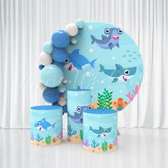 a party set with balloons, plates and cups for a baby shark themed birthday celebration