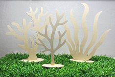 two paper cut out trees sitting on top of green grass