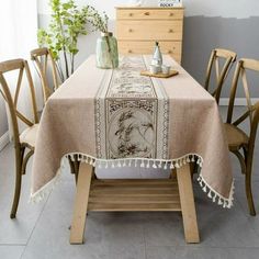 a dining room table covered in a beige linen